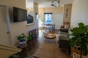 Living room, featuring a 3 seater couch, smart TV. decorated with live plants.
