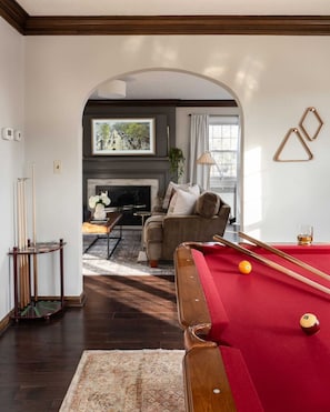 Pool table adjacent to living room.
