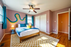 Serene bedroom with plush beddings, ceiling fan, and wardrobe