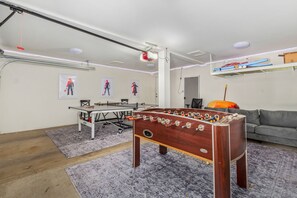 Game room with ping pong table, couch, and a foosball.