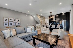 The living room features plenty of comfy seating and a large SmartTV for easy login to all your streaming services.