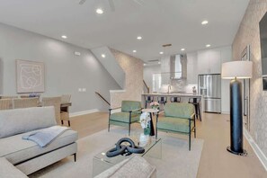 The living room features plenty of comfy seating and a large SmartTV for easy login to all your streaming services.
