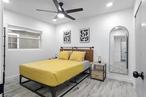 The bedroom features a comfortable queen-sized bed, a TV for your entertainment, and a ceiling fan to keep the space cool and breezy.
