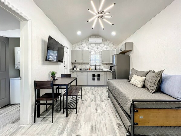 living room with trundle bed, dining room and kitchen