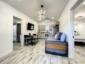 living room with trundle bed, dining room and kitchen