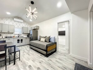 living room with trundle bed, dining room and kitchen