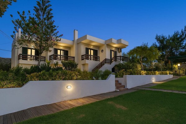 Elegant driveway entrance lit at dusk—your first glimpse of the villa’s charm

