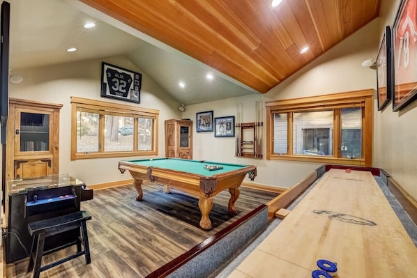 Game room with pool table, arcade game, and shuffle board.