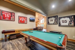 Game room with pool table, arcade game, and shuffle board.