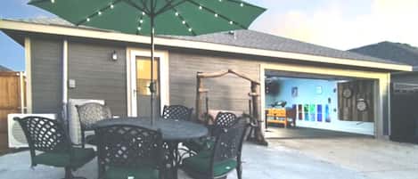 Unwind on the patio under the solar-lit umbrella—steps away from the game room fun!