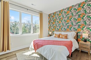 Bedroom with double bed with classic nightstands, and sunny window with curtains