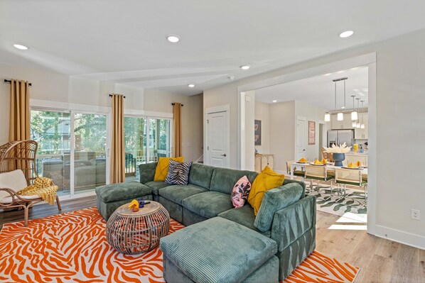 Eclectic living room with plush couch, windows with curtains
