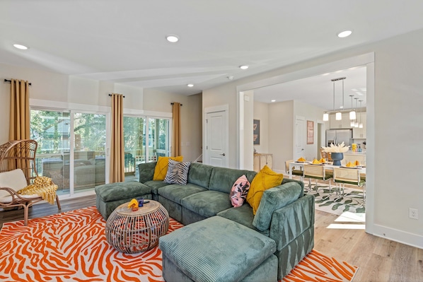 Eclectic living room with plush couch, windows with curtains