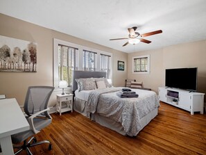Spacious bedroom 🛏️ with a comfy queen bed, smart TV 📺, and dedicated workspace 💻. Natural light fills the room, making it perfect for relaxing or working remotely.