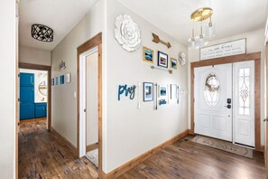 Welcome Home: Entry Decor & Hallway Leading to 2 Bedrooms and Guest Bathroom on Main Floor