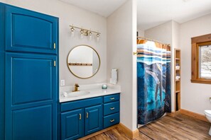 Pure Relaxation Awaits: Enjoy our vacation rental's spacious and private guest bathroom, conveniently located near the entry, office, and two bedrooms on the main floor's west wing.