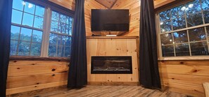 Enjoy cozy nights watching movies by the fireplace.