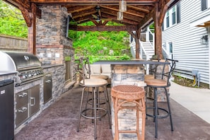 Gather under the stylish pavilion featuring a stone fireplace, TV, and grill for the ultimate outdoor hangout 🍔🔥📺