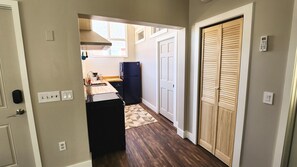 Kitchen equipped with an oven, dishwasher, fridge, and basic cooking utensils.