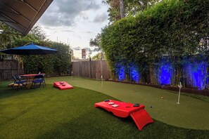 Turf yard with cornhole and minigolf