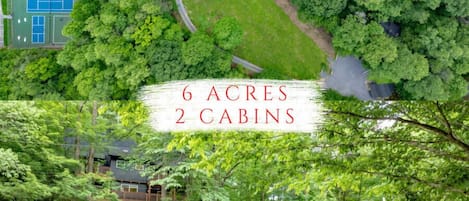 2 Cabins sit on 6 acres with tennis, pickleball and basketball basically on-site! Property hugs a creek throughout and is filled with a large lawn and 2 hot tubs!