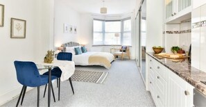 King size bed, bed side tables, a coffee table with armchair, dining table for two.