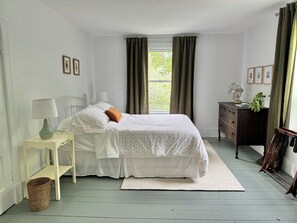 Bright and airy queen bedroom with plenty of space and storage.