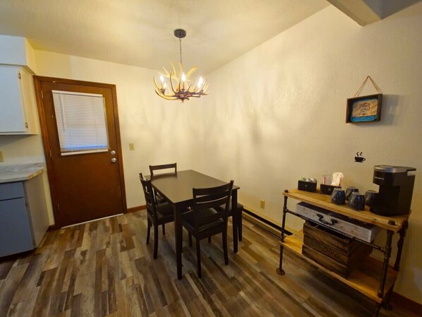 A spacious dining table and rustic-style coffee bar.