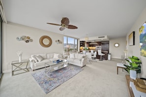 The spaciously designed living area has plush sofas and large windows and sliders for seamless indoor-outdoor living.