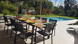 Espace repas extérieur, à l'ombre du store déroulant (1 table et 8 chaises)