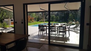 Vue du séjour sur l'espace repas extérieur