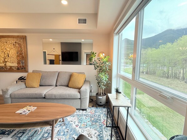 Living Room w Sofa Bed, Smart TV, Electric Fireplace and Beautiful Window View.