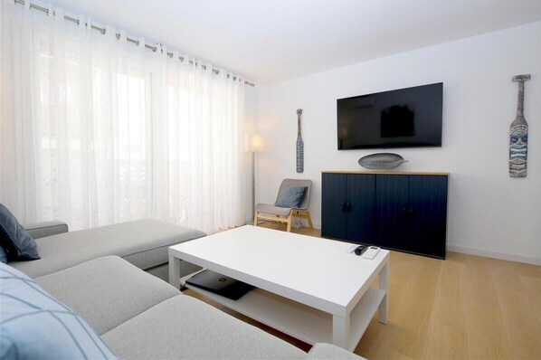 Modern and bright lounge area with comfortable seating and access to the balcony