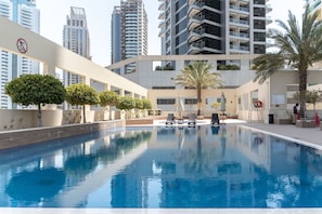 Pool Oasis: Dive into relaxation at our stunning pool surrounded by lush greenery and city views!