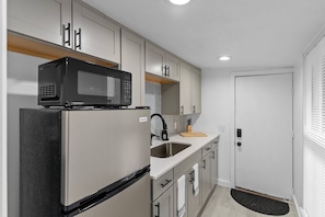 This compact kitchen is designed to maximize space and functionality. With cabinets in soft tones