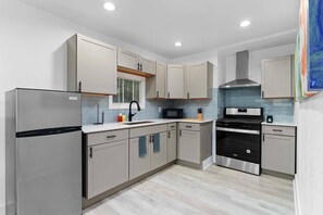 This modern kitchen is a functional space, equipped with neutral-toned cabinets that provide a clean and sophisticated atmosphere.