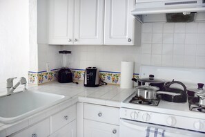 Fully equipped kitchen with a microwave, stove, oven and fridge. All utensils, plates and glasses are provided