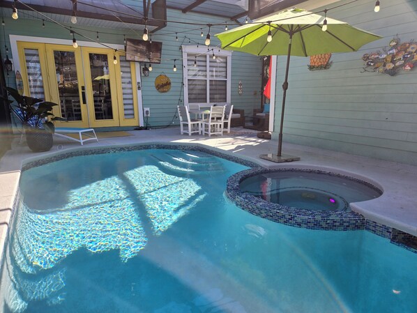 Private lush backyard with space to lounge, sun, and relax in the pool/spa.