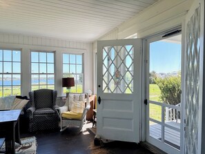 As you enter the cottage, you are greeted by the sun porch-