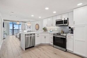 Beautifully remodeled kitchen with stainless steel full sized appliances, cookware, dishwater, bakeware, regular and Keurig coffee makers, large quartz peninsula with waterfall edge and convenient pantry cabinet.  