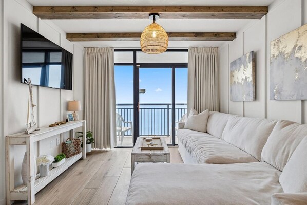 Stunning DIRECT ocean views in this gorgeous living room with unique wood beams, cozy large sofa and smart TV.  