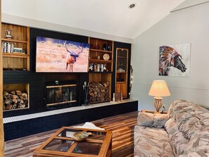 [Living area] Indoor wood fireplace & 65” Smart TV with Netflix