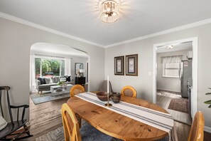 Rustic charm meets modern elegance in this inviting living room setting. Hardwood floors add warmth while the sleek dining table exudes sophistication.