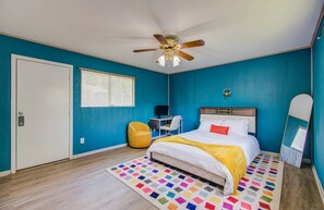 Bedroom with queen bed, ceiling fan, and dedicated workspace + standing mirror