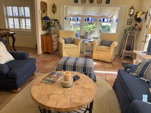 Living room with comfortable seating, fireplace, TV, and plenty of natural light