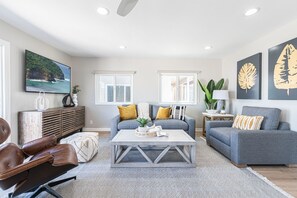 Guests can unwind in the inviting living room, furnished with a cozy sofa and a TV for relaxation. It's the perfect spot to kick back and enjoy some downtime.
                