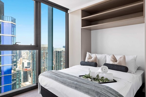 The master bedroom with a queen sized bed & plush pillows.