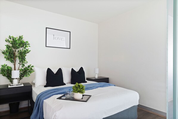 The master bedroom with a queen sized bed & plush pillows.