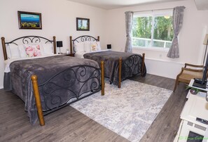 Bedroom 2 with two double beds. View of the patio and side yard. No neighbors.