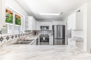 Elegantly designed fully stocked kitchen with maritime inspired backsplash.